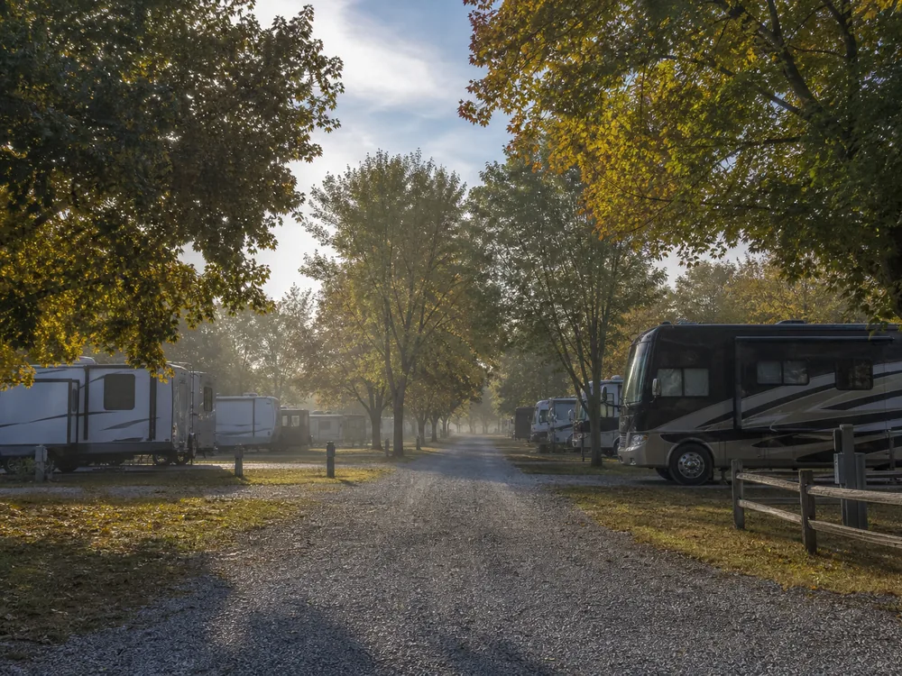 Gravel road between site rows at an RV park in early morning haze