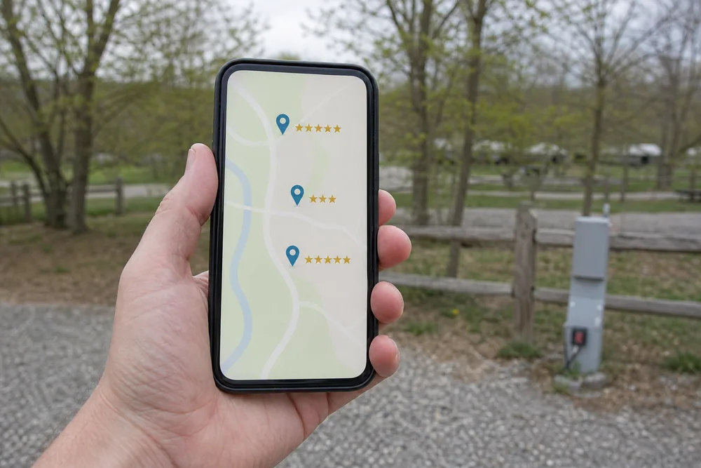 Camper comparing campground listings and star ratings on a phone